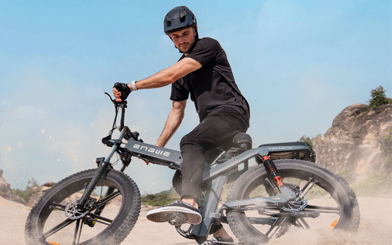 Ein Mann fährt mit einem Gravel-E-Bike durch den Sand