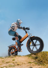  Ein Mann fährt mit einem orangenen Elektrofahrrad EP-2 Por in den Bergen