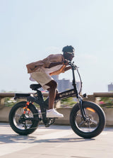 Ein Mann fährt mit einem schwarzen engwe x20 faltbaren E-Bike auf der Straße