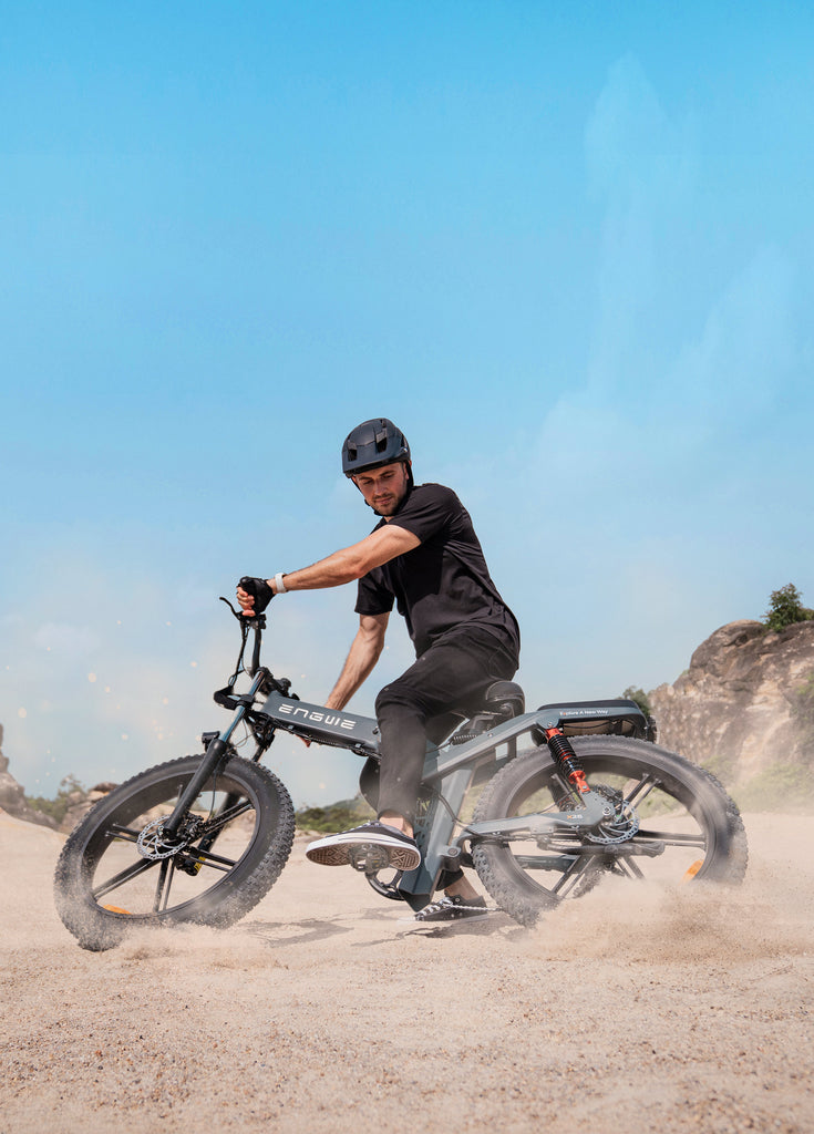 Ein Mann fährt mit einem engwe x26 E-Bike im Sand