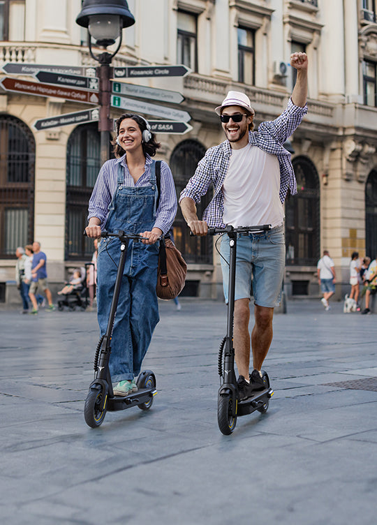 Ein Mann und eine Frau fahren glücklich mit dem E-Scooter Engwe Y10 auf der Straße