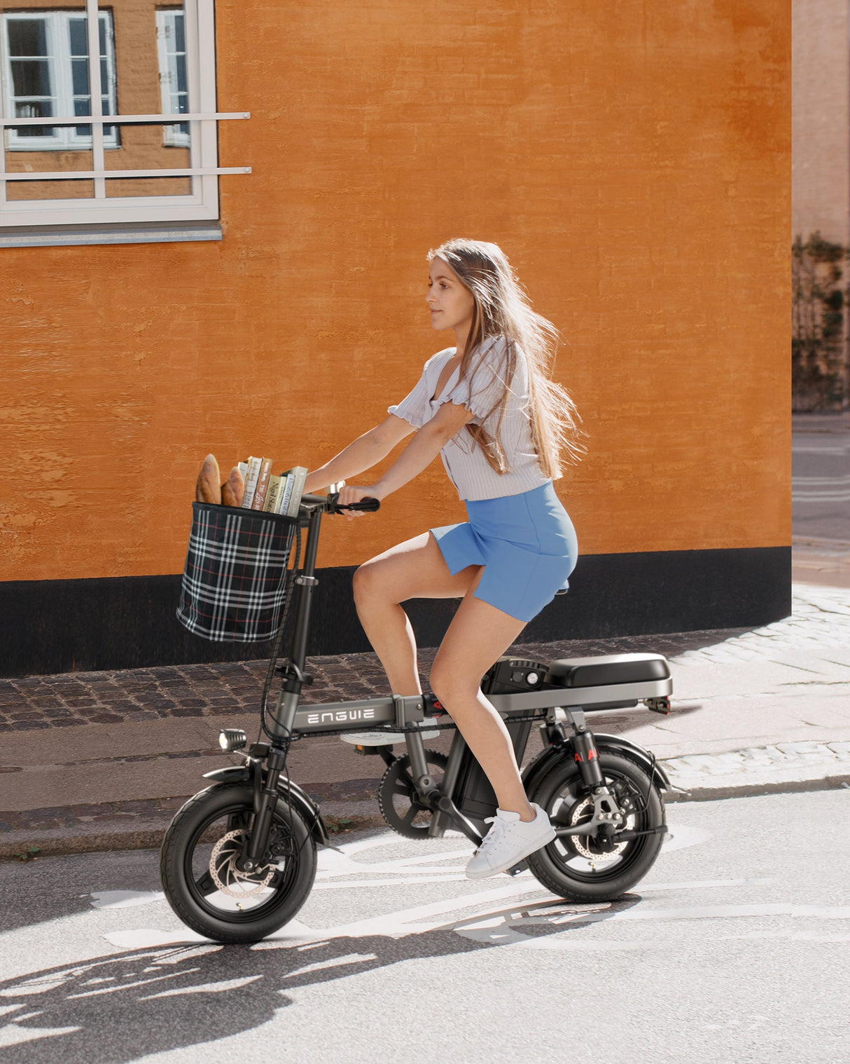 Ein Mädchen fährt ein graues engwe t14 E-Bike